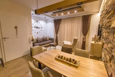 a living room with a wooden table and chairs at Family Apartmani Kopaonik in Kopaonik