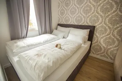 a white bed with two engagement rings on it at Family Apartmani Kopaonik in Kopaonik