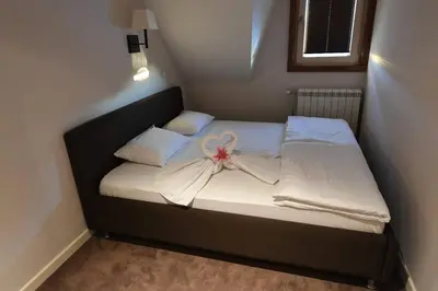 a small bed with a bow on it in a room at Župa Apartmani in Kopaonik