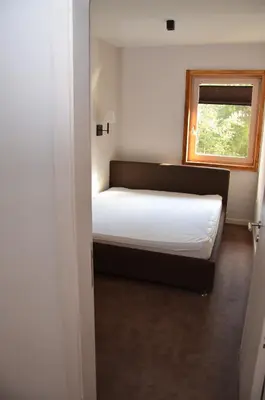 a bedroom with a bed and a window at Župa Apartmani in Kopaonik