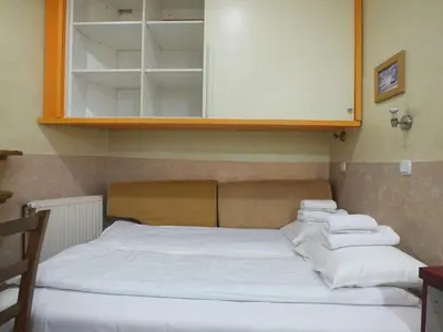 a bed with white sheets sitting under a cabinet at Apartment 102, Vila 