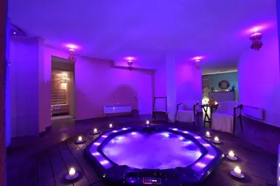 a purple room with a jacuzzi tub with candles in it at Apartments Topview Kopaonik-Dvori in Kopaonik