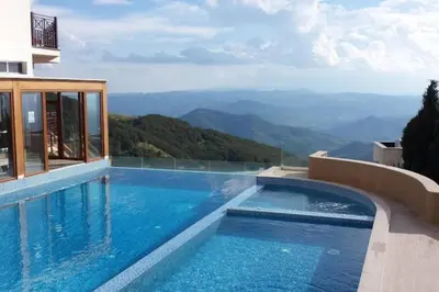 a swimming pool with a view of the mountains at Milmari Resort Premier 47 in Kopaonik