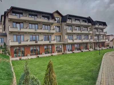 a large building with a green lawn in front of it at Milmari Resort Premier 47 in Kopaonik