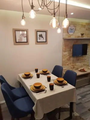 a dining room with a table and blue chairs at Milmari Resort Premier 47 in Kopaonik