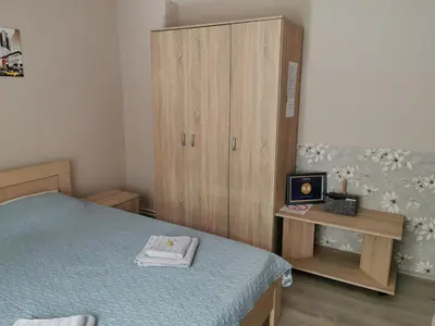 a bedroom with a bed and a wooden cabinet at Apartmani Milica in Kruševac