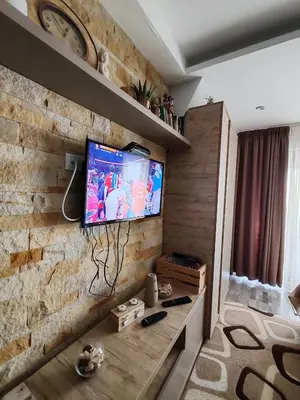 a living room with a tv on a brick wall at Ogi & Una Premijer 42 in Kopaonik