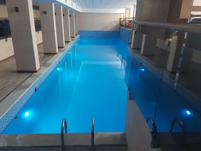 a swimming pool with blue lighting in a building at Ogi & Una Premijer 42 in Kopaonik