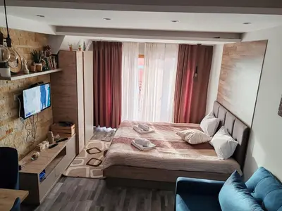 a bedroom with a large bed and a couch at Ogi & Una Premijer 42 in Kopaonik