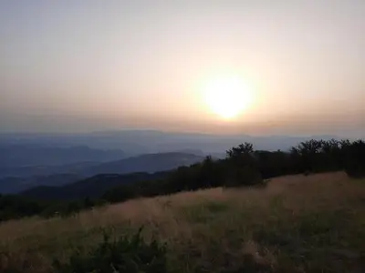 a sunset on top of a hill with the sun setting at Apartman Košuta, Kopaonik in Kopaonik