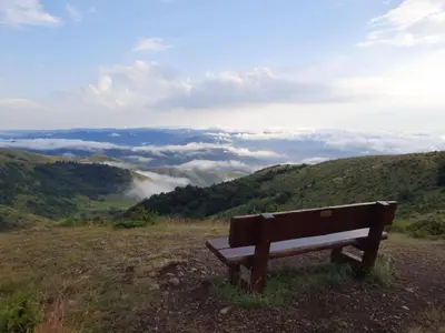 a bench sitting on top of a hill overlooking a valley at Apartman Košuta, Kopaonik in Kopaonik
