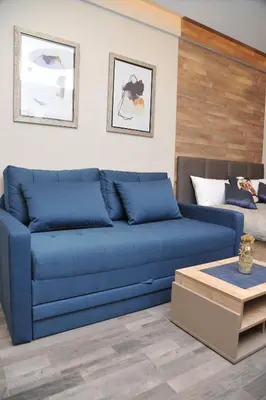 a blue couch in a living room with a table at MISS Premier 19 Milmari in Kopaonik