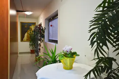 a room with a table with a vase of flowers on it at Apartments Imper - IMD in Niš