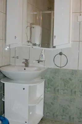 a bathroom with a sink and a mirror at Apartments Imper - IMD in Niš