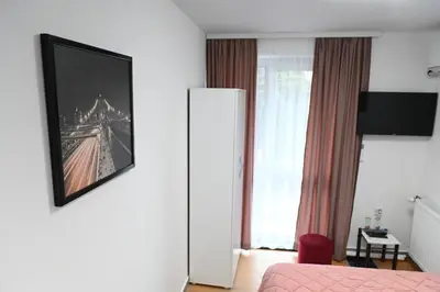a room with a bed and a picture on the wall at Apartments Imper - IMD in Niš