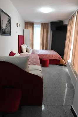 a hotel room with two beds and a window at Apartments Imper - IMD in Niš