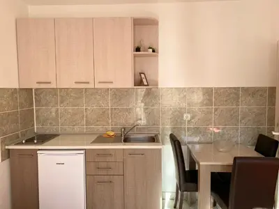a kitchen with a sink and a table with chairs at Bisa in Soko Banja