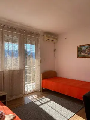 a bedroom with a red bed and a window at Bisa in Soko Banja