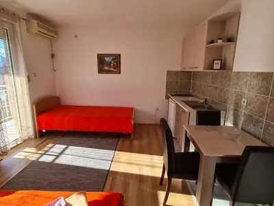 a kitchen with a red bed and a table at Bisa in Soko Banja