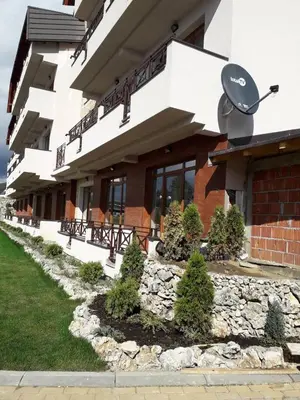 a building with a stone path in front of it at Apartman Lux Kopaonik in Kopaonik