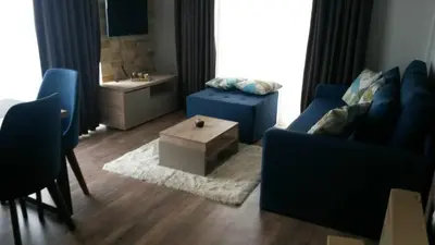 a living room with a blue couch and a table at Apartman Lux Kopaonik in Kopaonik