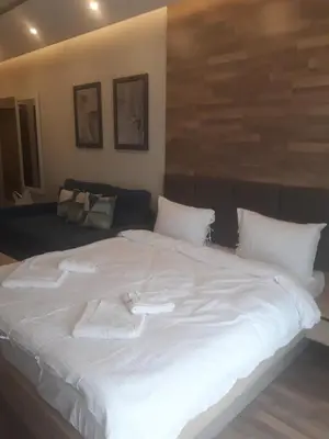 a large white bed with white sheets and pillows at Apartman Lux Premier 09 Kopaonik in Kopaonik