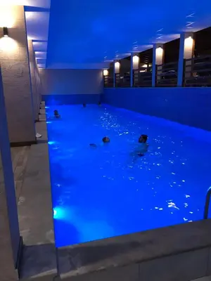 a group of ducks swimming in a pool with blue lights at Apartman Lux Premier 09 Kopaonik in Kopaonik