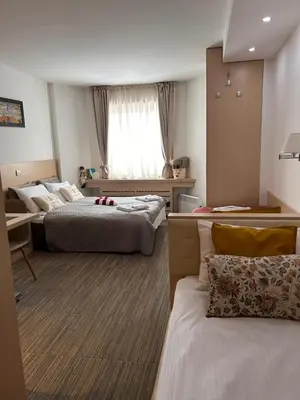 a hotel room with two beds and a window at Tri-M Konaci in Kopaonik
