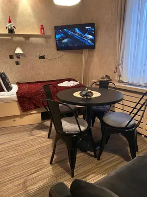 a room with a table and chairs and a bed at Tri-M Konaci in Kopaonik