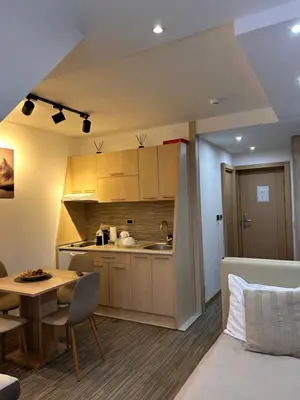 a kitchen and a living room with a table at Tri-M Konaci in Kopaonik