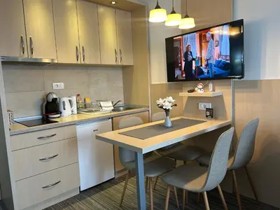 a kitchen with a table and chairs and a tv at Tri-M Konaci in Kopaonik