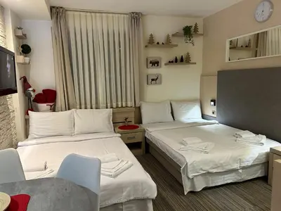 a hotel room with two beds and a tv at Tri-M Konaci in Kopaonik