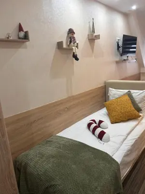 a person taking a picture of a bed in a room at Tri-M Konaci in Kopaonik
