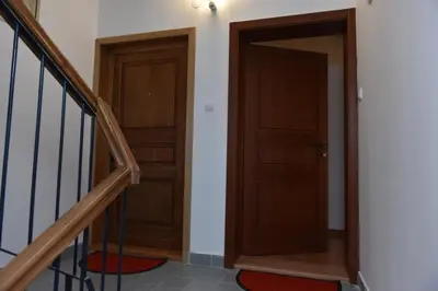 a hallway with two wooden doors and a staircase at Promenada apartmani in Kruševac