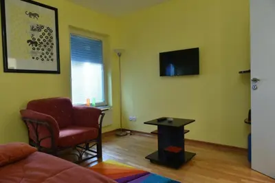 a living room with a couch and a chair and a table at Promenada apartmani in Kruševac