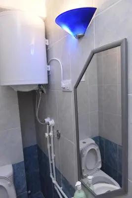 a bathroom with a toilet and a blue light at Promenada apartmani in Kruševac