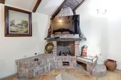 a living room with a stone fireplace with a mirror at PERLA Leskovac in Leskovac