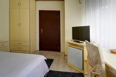a bedroom with a bed and a desk with a television at PERLA Leskovac in Leskovac