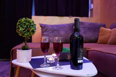 a bottle of wine and two glasses on a table at Wonderland spa apartment in Niš