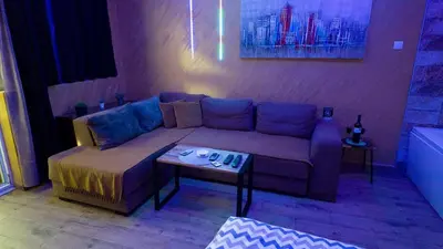 a living room with a couch and a table at Wonderland spa apartment in Niš
