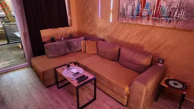 a living room with a couch and a table at Wonderland spa apartment in Niš