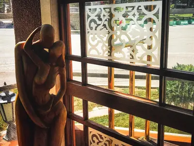 a statue sitting on a window looking out at a street at Hill Wellness & Spa in Jagodina