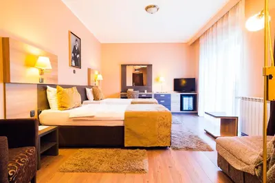 a hotel room with a large bed and a couch at Hill Wellness & Spa in Jagodina
