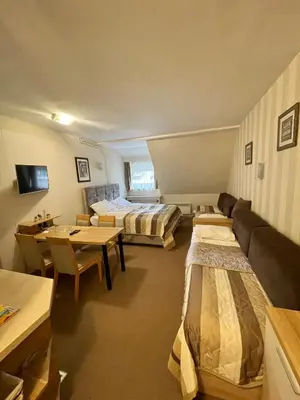 a hotel room with two beds and a couch at Apartments Konaci Kopaonik in Kopaonik