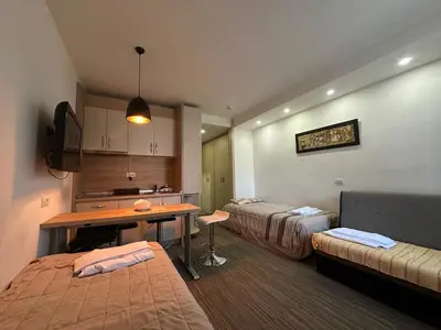 a room with two beds and a table in it at Apartments Konaci Kopaonik in Kopaonik