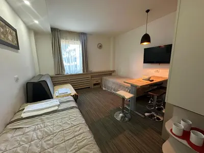 a hotel room with a bed and a desk with a computer at Apartments Konaci Kopaonik in Kopaonik