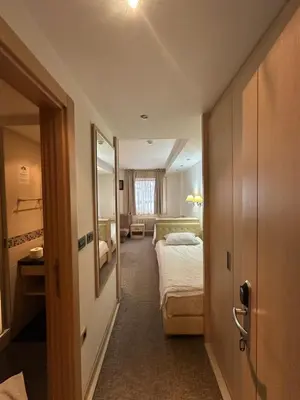 a hotel room with two beds and a mirror at Apartments Konaci Kopaonik in Kopaonik
