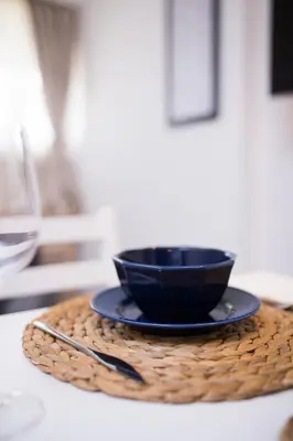 a black bowl on a plate on a table at Neva Apartment Angella Konaci in Kopaonik