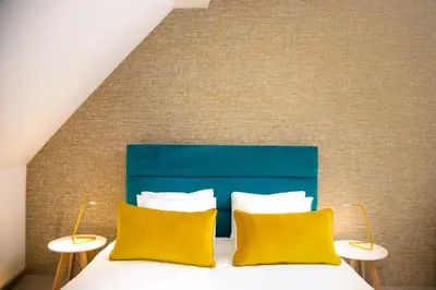 a bedroom with a bed with two yellow pillows at Neva Apartment Angella Konaci in Kopaonik
