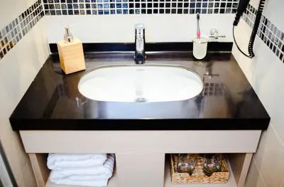 a bathroom sink with a black counter top at Neva Apartment Angella Konaci in Kopaonik